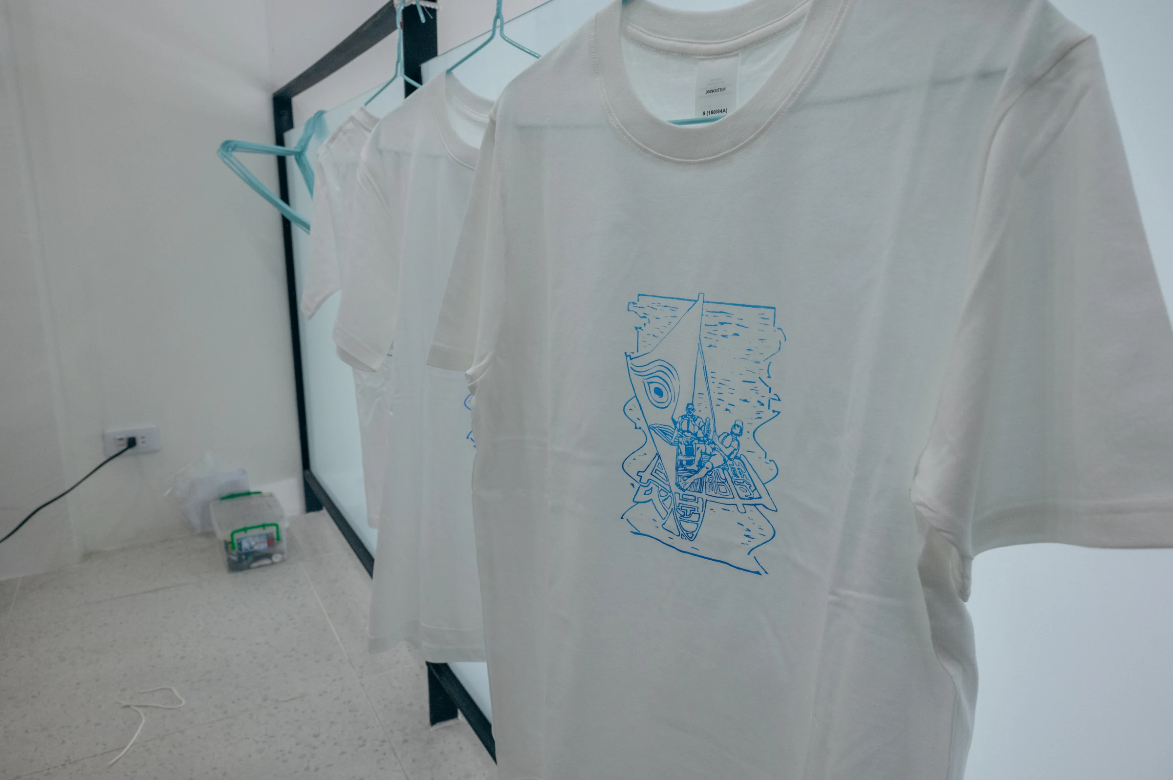 數件白色 T-shirt 吊掛展示藍色航海主題絹印作品